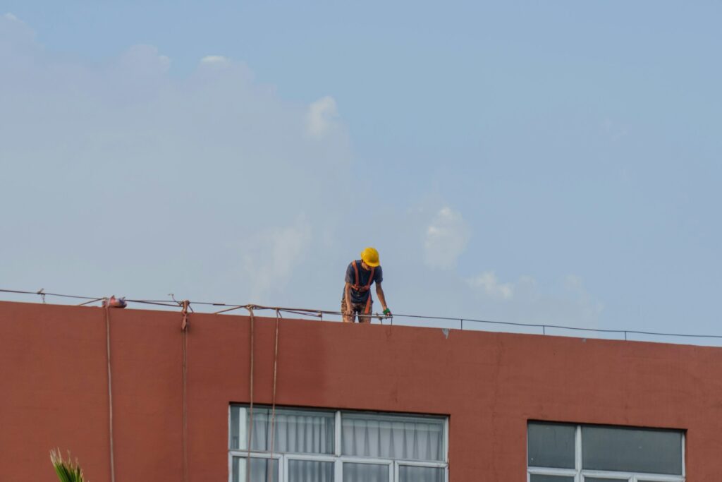 Person working construction on roof at a worksite